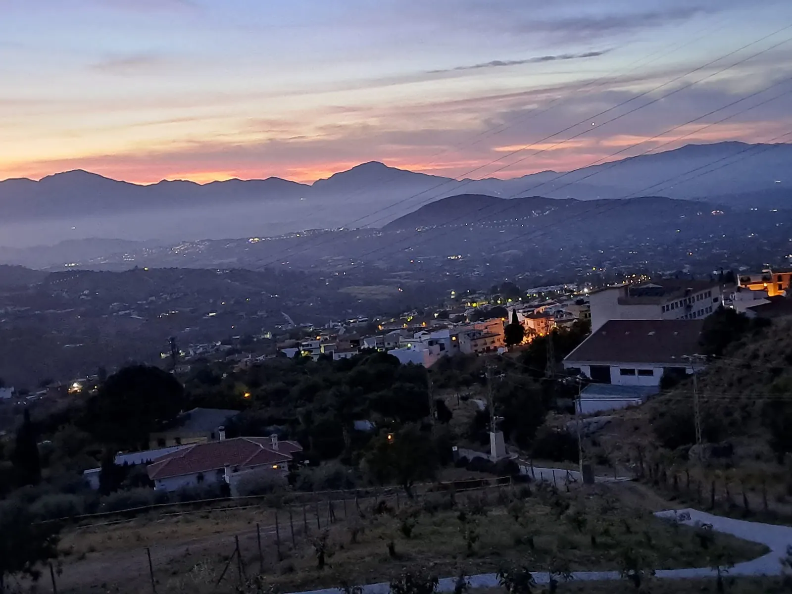 Dusk over the valley with village lights coming on below