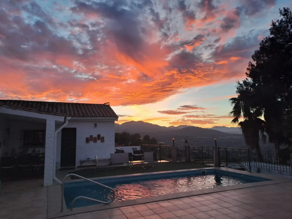Fiery sunset sky over the pool and the white casita