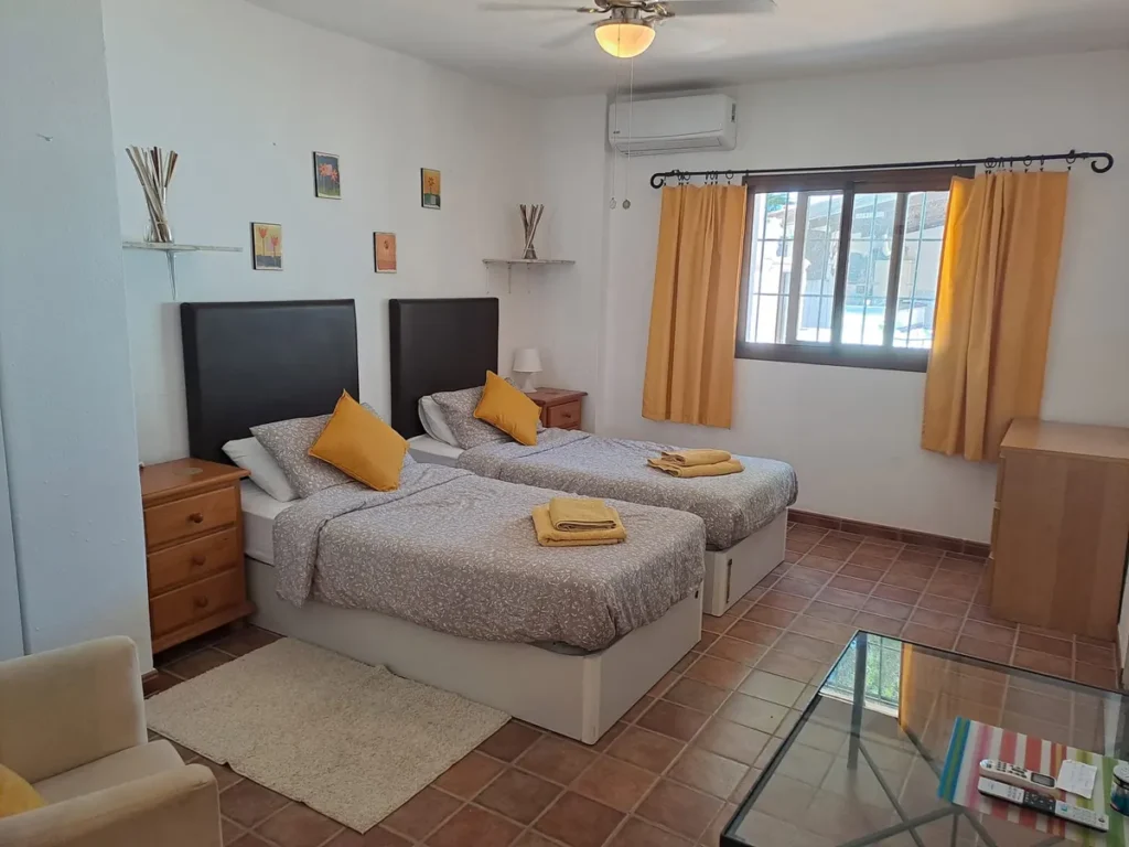 Twin room with two single beds and yellow cushions
